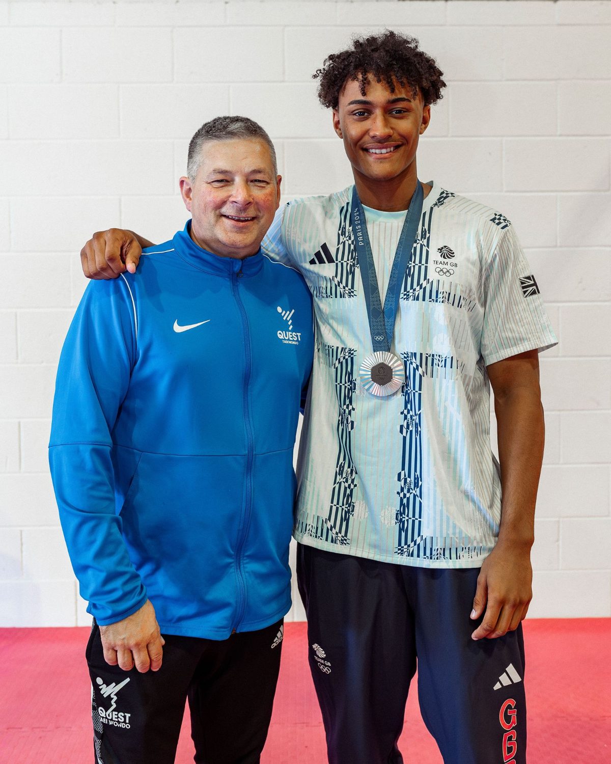 Master Mike McKenzie with Olympic silver medallist Caden Cunningham, wearing his Paris 2024 medal, at the Quest Taekwondo Centre